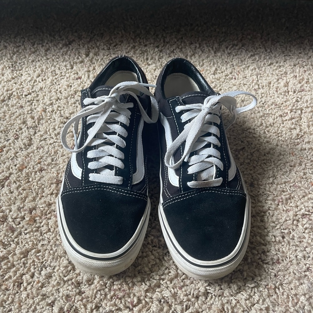 low top black sneakers by Vans